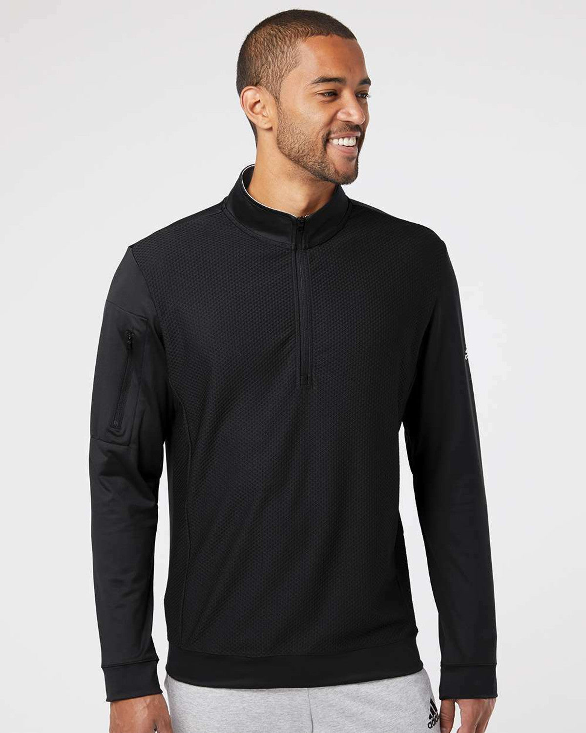 Man wearing a black customizable long-sleeve shirt with a quarter zip on a white background